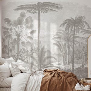 May include: A bedroom with a white bed with brown bedding and a white headboard. The wall behind the bed is covered in a wallpaper with a gray and white palm tree design. There is a mirror on the right side of the image.