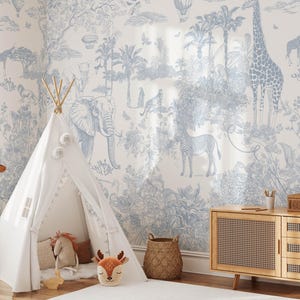 May include: A white fabric teepee tent stands in a room with light blue and white toile wallpaper featuring illustrations of giraffes, elephants, zebras, and tropical trees. A plush giraffe toy stands to the left of the teepee in the room.