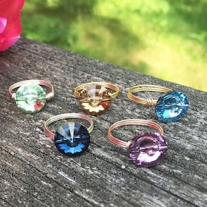 Peut inclure: Cinq bagues en fil d'or avec des perles de verre de différentes couleurs. Les perles sont vertes, brunes, bleues, turquoise et violettes.