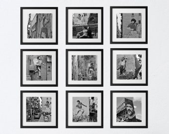 May include: Nine black framed photographs of a person in various poses, all in black and white. The photos are hung on a white wall.