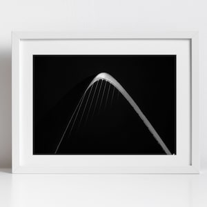 Puede incluir: Fotografía en blanco y negro de un arco de puente contra un cielo oscuro.