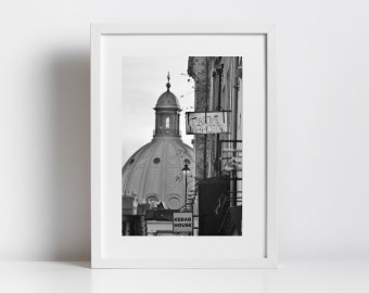 May include: Black and white photograph of a building with a dome, a sign that says "KEBAB HOUSE", and graffiti on the side of the building.