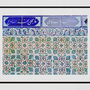 May include: A close-up of a wall covered in intricate blue, green, and white patterned tiles. The tiles feature floral designs and Arabic calligraphy.