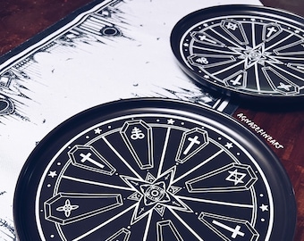 Könnte beinhalten: Ein rundes, schwarz-weißes Tablett mit einem Design aus Särgen und Symbolen. Das Tablett hat einen schwarzen Hintergrund und weiße Särge mit Symbolen darauf. Die Särge sind in einem Kreis um einen zentralen Stern angeordnet.