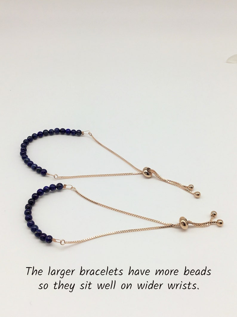 May include: Two adjustable bracelets with a gold chain and blue gemstone beads. The larger bracelet has more beads.