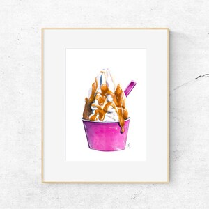 May include: Watercolour painting of a frozen yogurt dessert in a pink cup, drizzled with caramel sauce. A pink spoon rests in the cup. The artwork is framed in a white mount and a light wood frame.