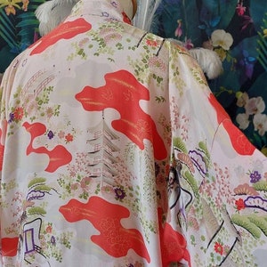 Peut inclure: Un kimono blanc avec un motif floral rouge, vert et or. Le kimono présente une pagode et d'autres images japonaises traditionnelles.