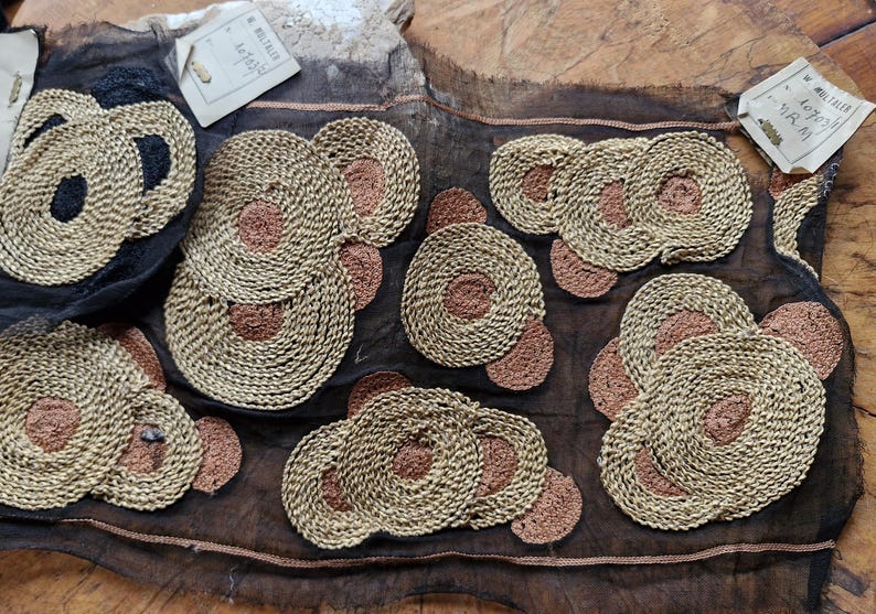 May include: A black sheer fabric with gold and brown embroidered circles. The fabric has a vintage look and feel.