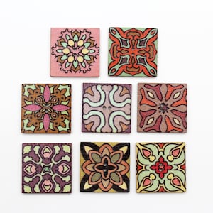 May include: Nine square wooden buttons with intricate geometric patterns in shades of pink, green, brown, and orange. The buttons are approximately 1 inch in size.