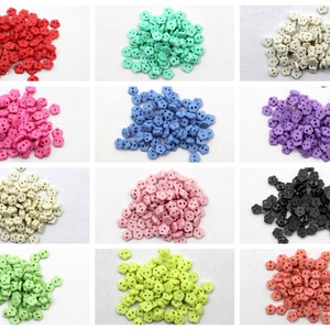 May include: A collection of small, flower-shaped buttons in various colors, including red, green, white, pink, blue, purple, cream, black, light green, yellow-green, and coral. Each button has two holes for sewing.