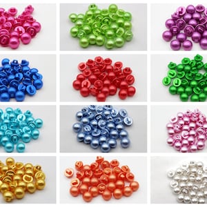 Peut inclure: Assortiment de boutons perlés de différentes couleurs, dont rose, vert, bleu, rouge, turquoise, bleu clair, or, orange et blanc. Les boutons ont une finition brillante et un dos plat avec une tige.