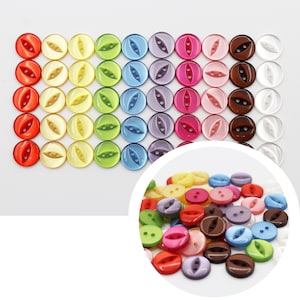 May include: Assortment of colorful plastic buttons with two holes. The buttons are arranged in rows by color, starting with red and ending with white. The buttons are all the same size and shape.