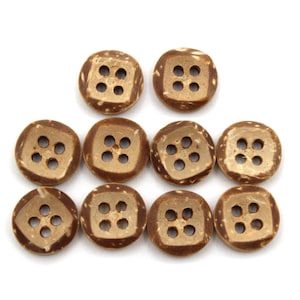 May include: A collection of ten natural coconut shell buttons. Each button is square with rounded corners and four evenly spaced holes. The buttons have a light brown color with darker brown accents.