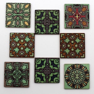 May include: Nine square wooden buttons with intricate, colorful designs. The buttons feature patterns in shades of green, brown, black, and yellow. Each button has a unique floral or geometric design, with a small hole in the center.