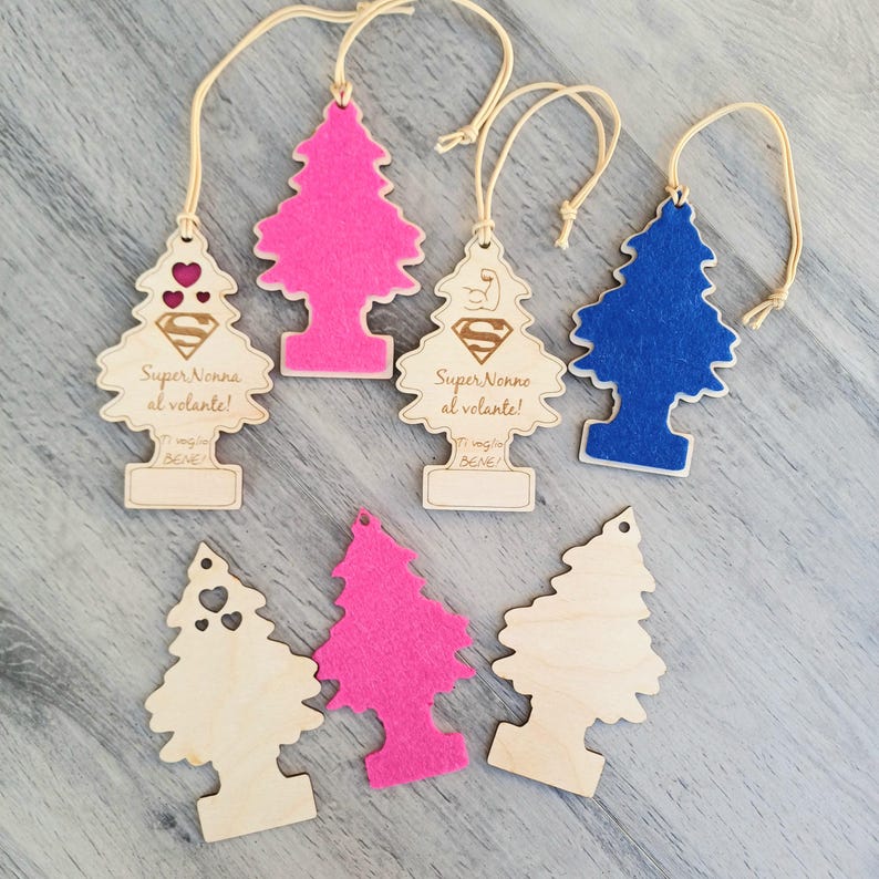 Puede incluir: Varios ambientadores para coche con forma de &aacute;rbol de Navidad. Algunos son de madera con recortes de coraz&oacute;n y texto, otros de fieltro rosa y azul. Cada uno tiene una cuerda para colgar, algunos con texto italiano.