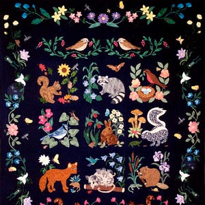 May include: A colorful quilt with a dark blue background featuring various animals and plants. The animals include a fox, a raccoon, a squirrel, a beaver, a rabbit, a skunk, a bird, and a hedgehog. The plants include flowers, leaves, and mushrooms.
