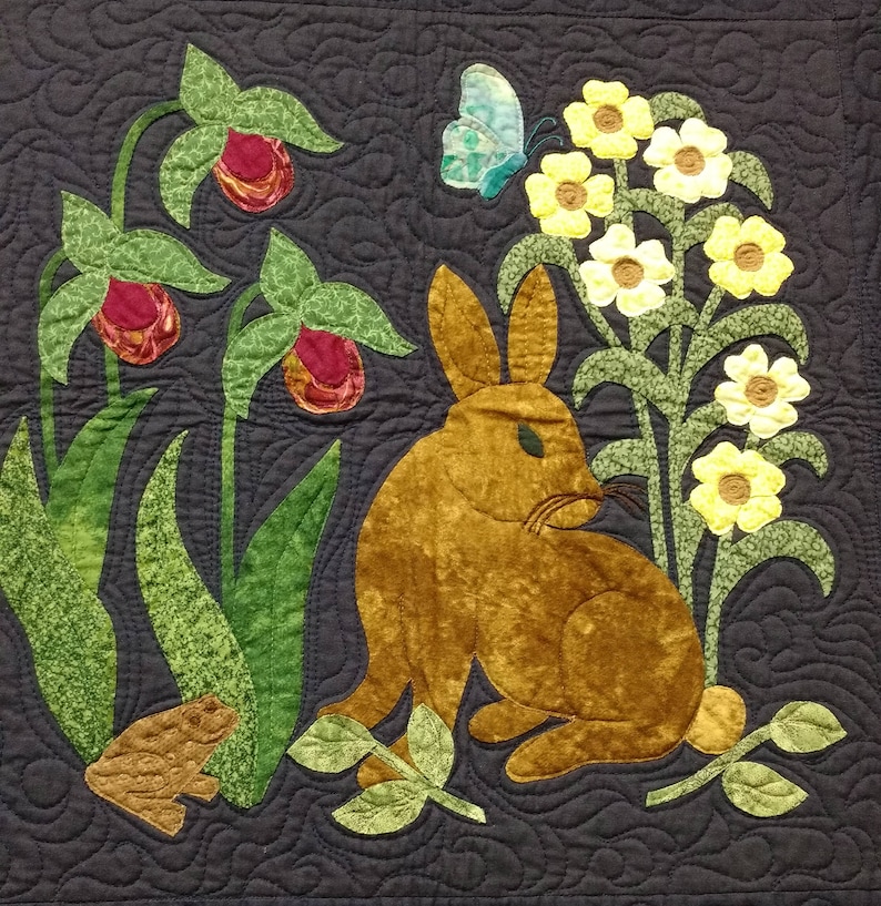 K&ouml;nnte beinhalten: Ein braunes Kaninchen sitzt in einem Feld mit gelben Blumen und gr&uuml;nen Bl&auml;ttern. Ein blauer Schmetterling fliegt &uuml;ber den Blumen. Im Hintergrund sind auch rosa Blumen zu sehen.