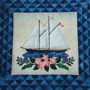 May include: A white sailboat with a Canadian flag and a blue and white flag on the mast, sailing on a blue and white patterned background with a floral border of pink flowers and green leaves.