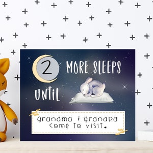 May include: A blue and white countdown sign with a crescent moon and stars. The sign says "2 More Sleeps Until Grandma & Grandpa Come to Visit."