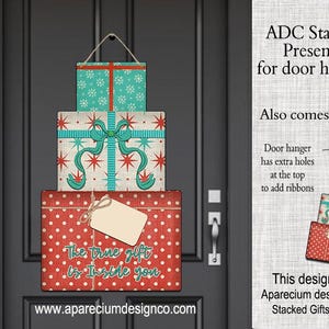 May include: Stacked gift boxes door hanger with a red polka dot base, a middle box with a bow, and a top box with a snowflake pattern. The text "The true gift is inside you" is on the bottom box. The design fits Aparecium design Co. Stacked Gifts Blank.