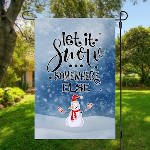 May include: A blue and white garden flag with a snowman and the text "Let it snow... somewhere else."