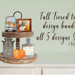 以下が含まれることがあります： 素朴な仕上げの2段の木製トレイで、秋のテーマのアイテムで飾られています。 上段には、カボチャを積んだビンテージトラック、