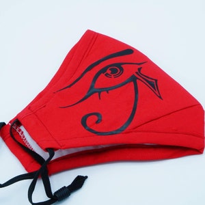 May include: Red face mask with a black eye of Horus design. The mask has black elastic straps.