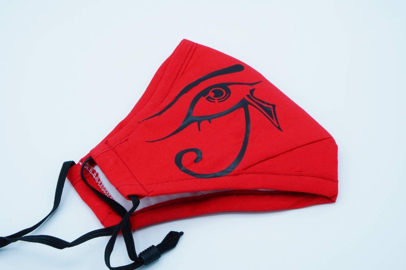 May include: Red face mask with a black eye of Horus design. The mask has black elastic straps.