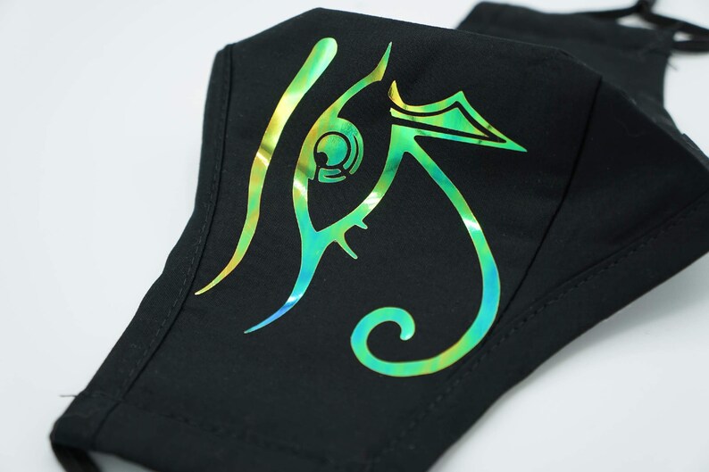 May include: Black face mask with a green, blue, and gold iridescent eye design.
