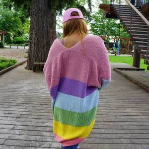 May include: A pink, purple, blue, green, and yellow striped cardigan with a V-neck.