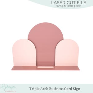 May include: A triple arch business card sign in shades of pink. The sign features a semi-circle and two arched shapes, with a rectangular base. The text "LASER CUT FILE" and "Triple Arch Business Card Sign" are visible.