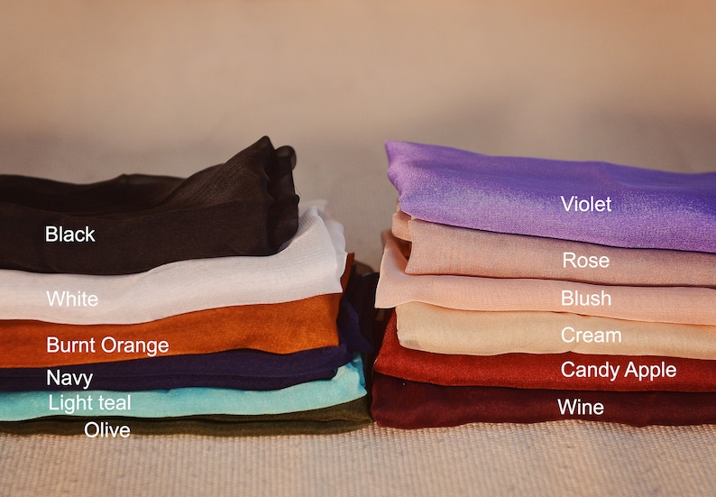 May include: A stack of fabric swatches in various colors, including black, white, burnt orange, navy, light teal, olive, violet, rose, blush, cream, candy apple, and wine.
