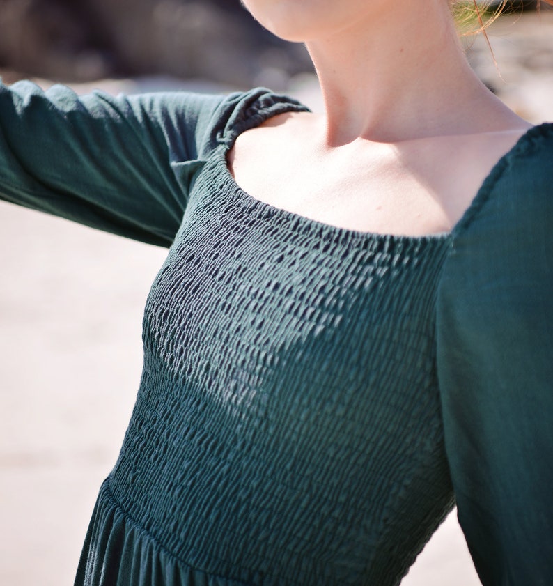 May include: A dark green, long-sleeved dress with a square neckline and a gathered bodice.