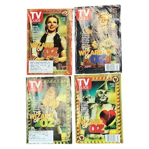 May include: Four vintage TV Guide magazines featuring characters from The Wizard of Oz. Each cover has a different character, including Dorothy, the Cowardly Lion, the Scarecrow, and the Tin Man. The magazines have a retro aesthetic.