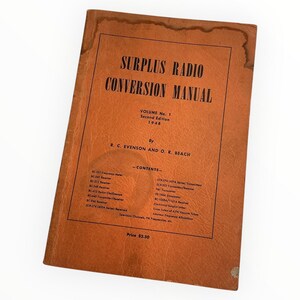 May include: A vintage, brown "Surplus Radio Conversion Manual" book. The cover features the title in bold, black text, along with "Volume No. 1, Second Edition 1948." The book's cover also lists the authors and a table of contents.