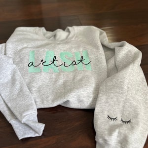 EMBROIDERED Lash Artist sweatshirt and lashes on the sleeve.   Trendy "Lash Artist" Embroidered Sweatshirt  with embroidered sleeve design