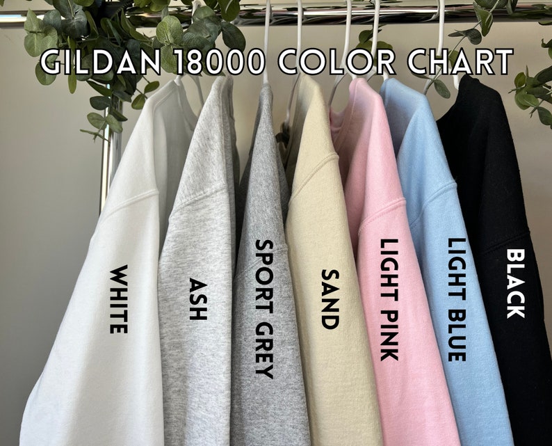 May include: Color chart for Gildan 18000 sweatshirts, showing the colors white, ash, sport grey, sand, light pink, light blue, and black.