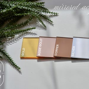 May include: Four mirrored acrylic sheets in gold, rose gold, copper, and silver. The sheets are arranged horizontally with the gold sheet on the left and the silver sheet on the right.