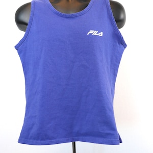May include: A purple tank top with the word "FILA" in white lettering on the front.
