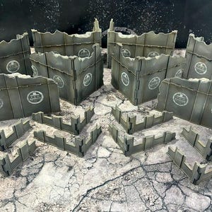 May include: A set of 10 grey and brown textured cardboard pieces that can be assembled into a variety of ruined wall configurations. The pieces are designed for use in tabletop wargaming and feature a distressed, weathered look.