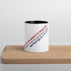 May include: White ceramic mug with a black rim. The mug has a diagonal design of text that reads "There's no point in saying good morning because it certainly is not one."