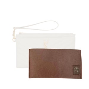 Peut inclure: Une pochette en cuir blanc avec un logo YSL doré et une pochette en feutre marron avec un logo doré. La pochette a une bandoulière blanche.