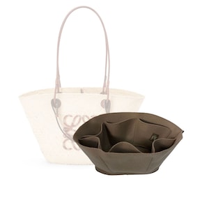 Könnte beinhalten: Ein brauner Filz-Taschenorganizer mit mehreren Fächern für eine Einkaufstasche. Der Organizer hat eine rechteckige Form mit abgerundetem Boden und ist so konzipiert, dass er in eine größere Tasche passt.