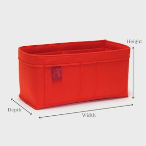Könnte beinhalten: Ein leuchtend roter Handtaschen-Organizer mit rechteckiger Form und mehreren Fächern. Der Organizer hat ein strukturiertes Design. Ein kleines rechteckiges Etikett mit den Buchstaben "AI" befindet sich auf der Vorderseite. Tiefe, Breite und Höhe sind beschriftet.