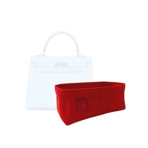 May include: Red felt bag insert with a small logo in the centre. The insert is designed to fit inside a handbag and help keep it organised.