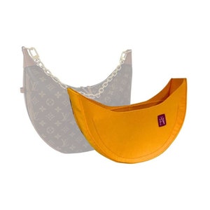 Op de afbeelding: Een gele vilt tas insert voor een halvemaanvormige handtas. De insert heeft een klein rood label met de letters "LV" erop.