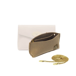 Könnte beinhalten: Eine weiße Ledertasche mit einer goldenen Kettenkette und einem Filzeinsatz. Die Filztasche hat eine Tasche und ein Logo.