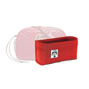 Peut inclure: Insert de sac en feutre rouge avec une petite étiquette blanche qui dit "Keeping My Angels Safe".