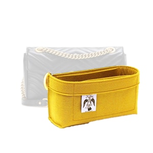 Peut inclure: Organiseur de sac en feutre jaune avec une petite étiquette indiquant "J.Geller Designs".