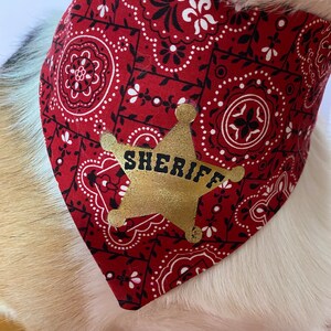May include: Red bandana with a white and black paisley pattern and a gold star with the word "SHERIFF" on it.
